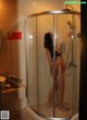 A woman standing in a shower next to a sink.