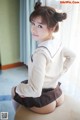 A woman in a school uniform sitting on a chair.