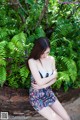 A woman sitting on a brick wall with her arms crossed.