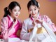 A couple of young women dressed in traditional Korean clothing.