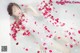 A woman laying in a bathtub filled with rose petals.