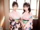 Two young women in kimonos standing next to each other.