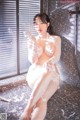 A woman sitting on the floor in a bathroom covered in foam.