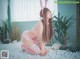 A woman in a pink bunny costume sitting on a bed of white pebbles.