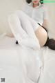 a woman in white stockings is laying on a bed