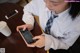 A young girl sitting at a table looking at her phone.