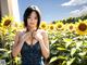 A woman standing in a field of sunflowers.