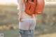 A woman with a backpack standing in a field.