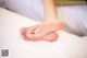 A close up of a person's feet on a bed.