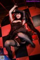 A woman in a corset and stockings laying on a checkered floor.