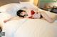 A woman laying on a bed in a red lingerie.