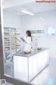 A woman standing in front of a counter in a pharmacy.