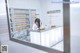 A woman sitting at a counter in a pharmacy.