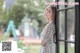 a woman standing in front of a window looking out the window