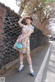 A woman in a floral dress is posing for a picture.