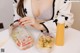 A woman sitting at a table with two plastic containers of food.