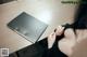 A woman sitting at a desk with a laptop computer.