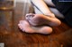 A woman's feet in black stockings on a wooden table.