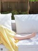 A woman in a yellow dress sitting on a white couch.